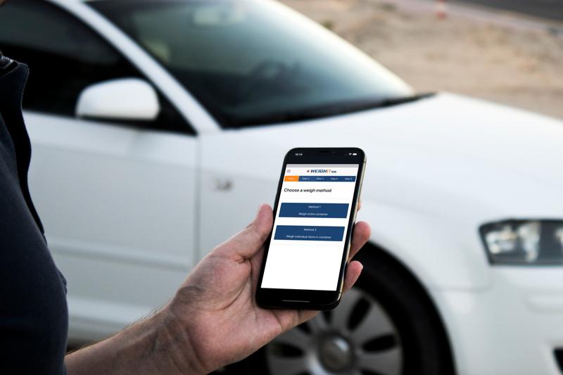 Man on iPhone near white car